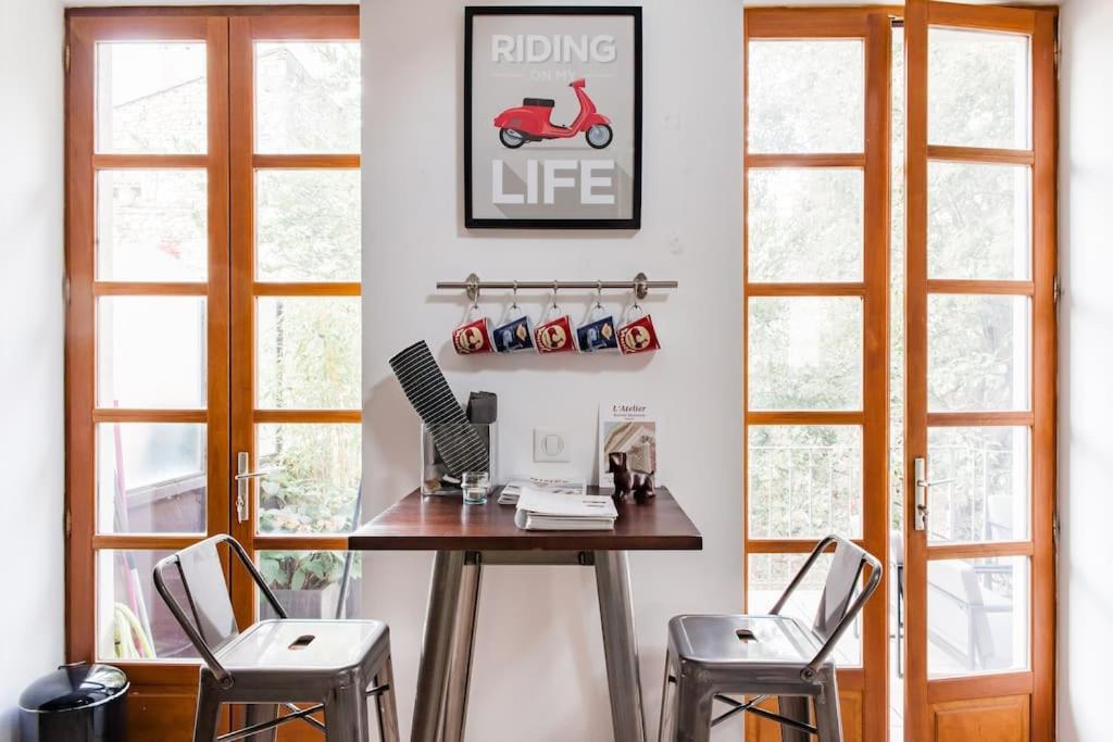 un bureau avec une table et deux tabourets dans l'établissement Baignez dans la lumière d'un loft nîmois au caractère unique, à Nîmes