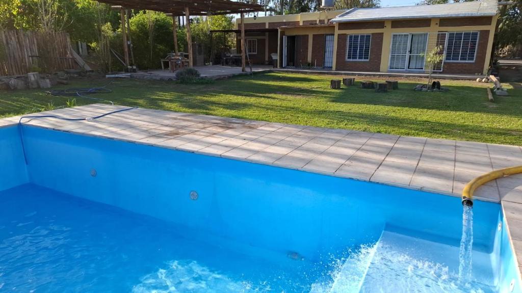 a swimming pool with a water feature in a yard at Sol y Sombra - Cabaña - Zonda - San Juan in Zonda