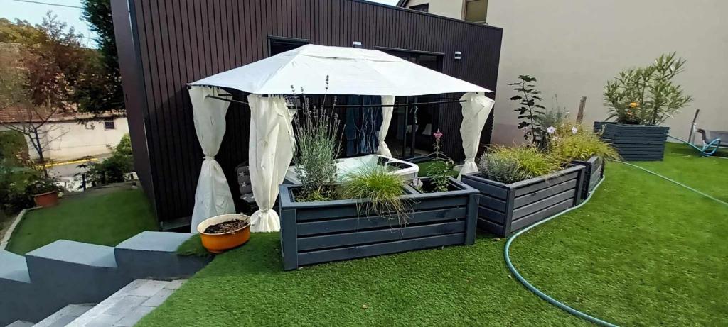 a gazebo with an umbrella in a yard at Au fond du jardin in Wintzenheim-Kochersberg