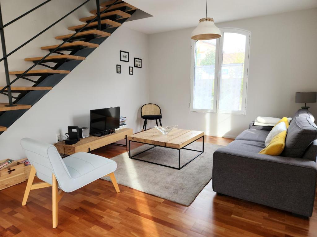 un salon avec un canapé et une table dans l'établissement À 300m de la plage, maison pour 7 avec piscine, à Lanton