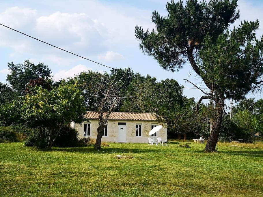 une petite maison blanche dans un champ arboré dans l'établissement La maison vieille, à Hourtin