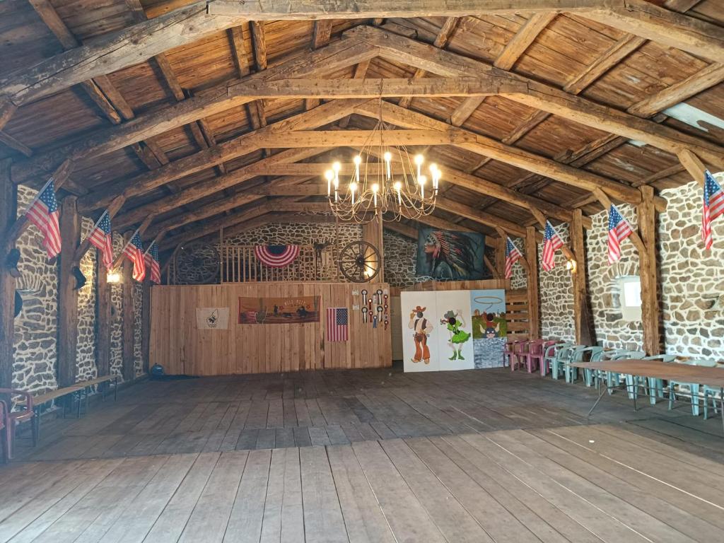 Cette grande chambre est dotée d'un plafond en bois et d'un lustre. dans l'établissement GITE Le SALOON, à Mazan-lʼAbbaye
