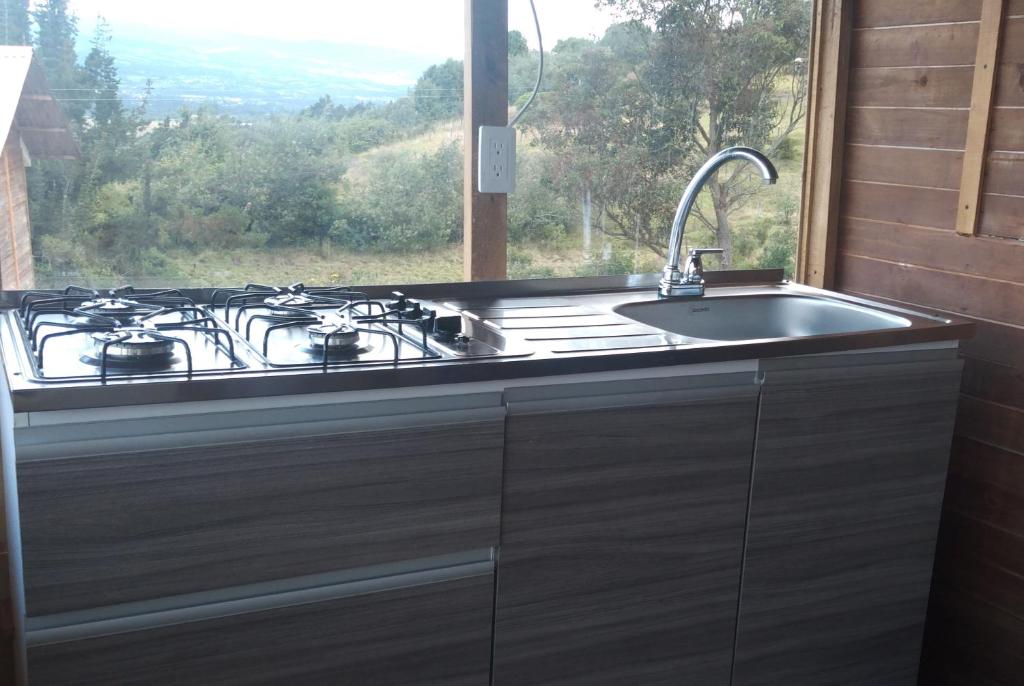 una cucina con piano cottura e lavandino con finestra di El Mirador de Juan a Guasca