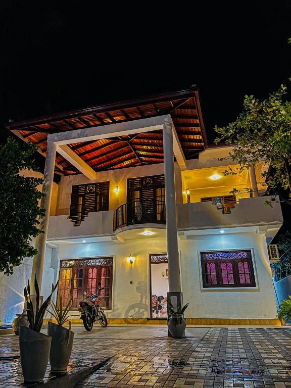 a house with a motorcycle parked in front of it at Zinera Homestay Ahangama in Ahangama