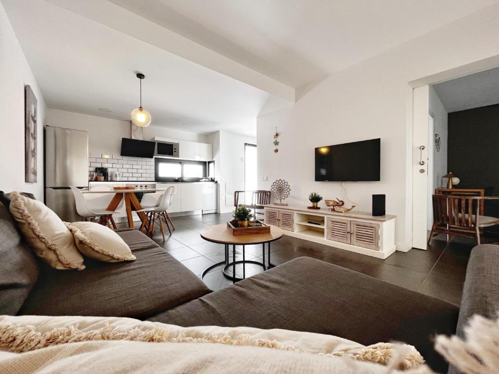 Una sala de estar con un sofá y una cocina. en Apartment Sleeps 4 with Scenic Views, en Villaverde