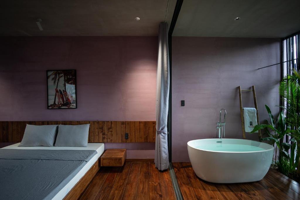 a bedroom with a bed and a bathtub and a bed and a tub at AnNam Boutique Room in Vung Tau