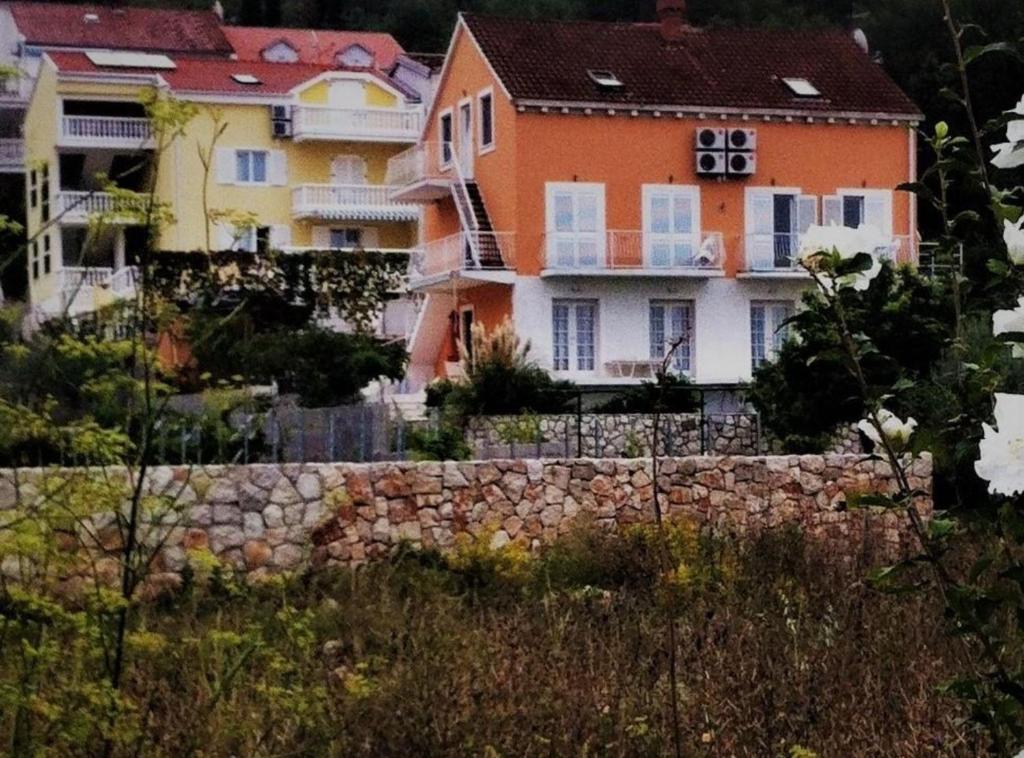 a group of houses behind a stone wall at Apartments Villa Novak in Slano