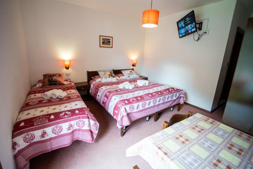 a bedroom with two beds and two tables in it at Cèsa Cherpei - Dog Friendly in Campitello di Fassa