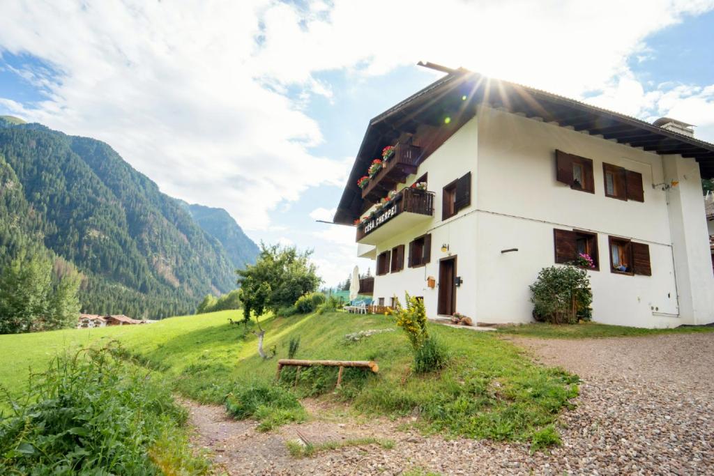 a house on a hill with the sun shining at Cèsa Cherpei - Dog Friendly in Campitello di Fassa