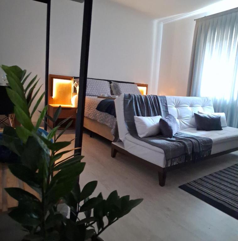 a living room with a couch and a bed at Loft Moderno Goēde in Pomerode