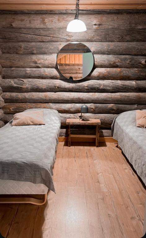 a bedroom with two beds and a table with a mirror at Kelotulkku Lodge in Muurame