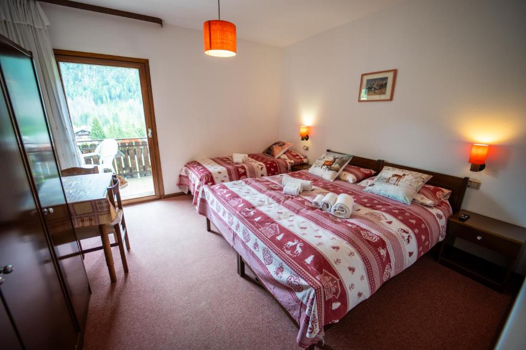 a bedroom with two beds and a window at Cèsa Cherpei - Dog Friendly in Campitello di Fassa