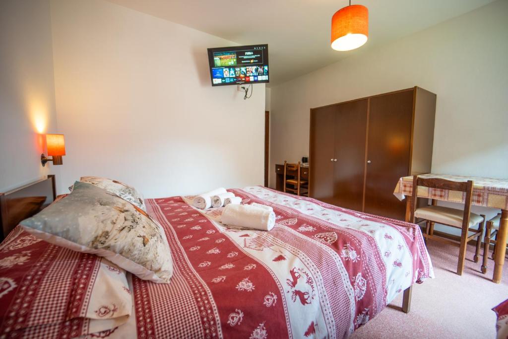 a bedroom with a bed and a tv on the wall at Cèsa Cherpei - Dog Friendly in Campitello di Fassa