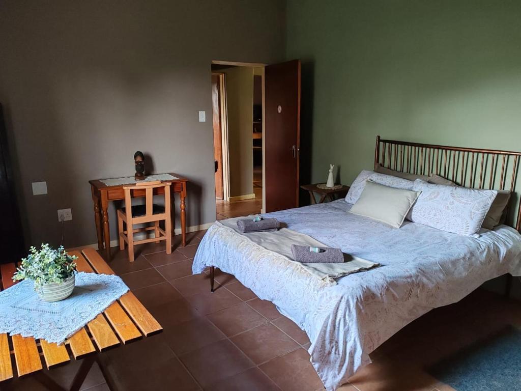 a bedroom with a large bed and a table at 83 on De Lange in Graskop