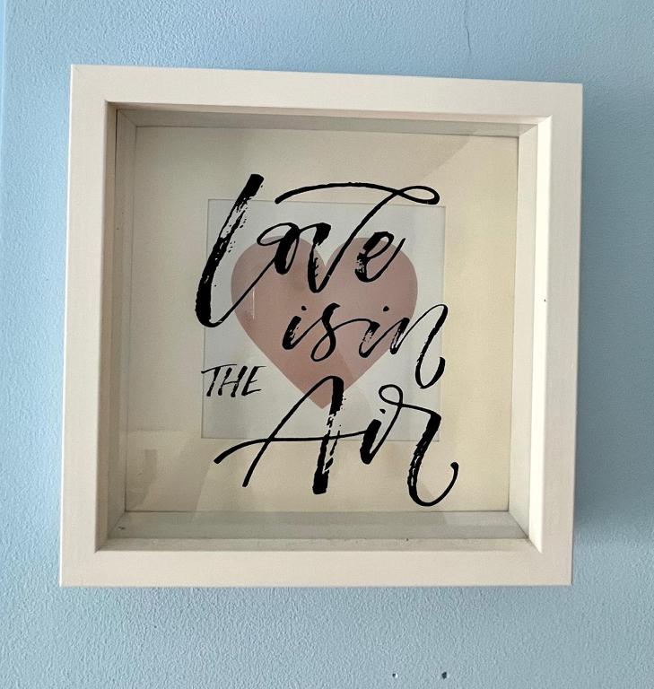 a picture of a sign that says love is in the air at Apartment Aurora in Buzin