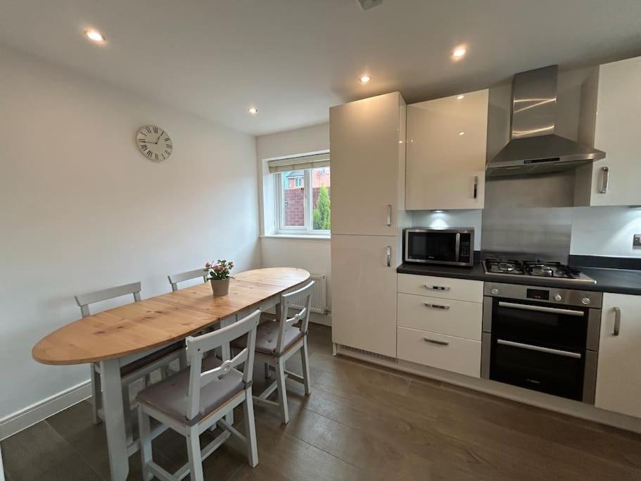 a kitchen with a wooden table and a stove top oven at Nice house close to the city centre and stadium in Manchester