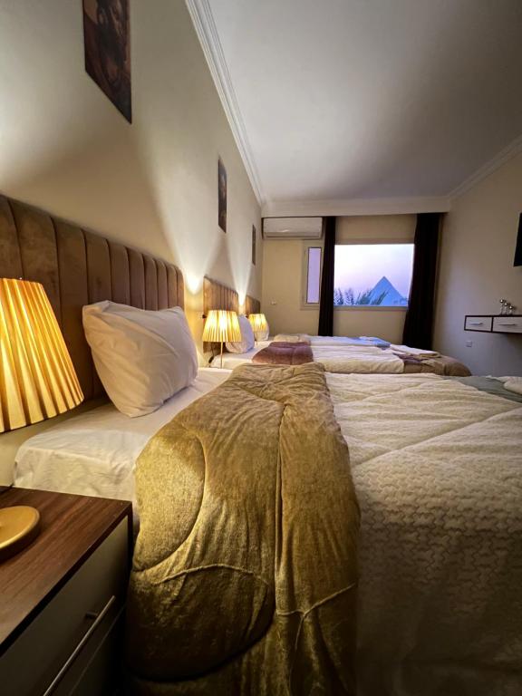 Postel nebo postele na pokoji v ubytování Pyramids moon view inn