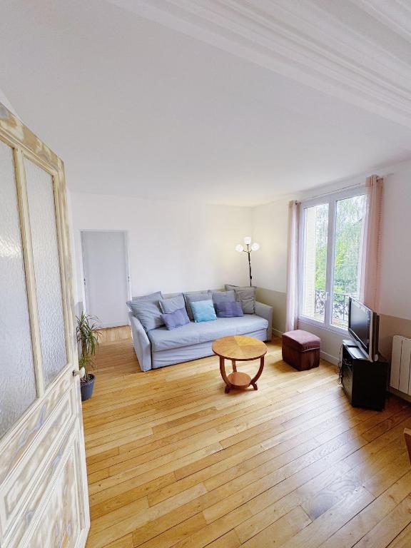 un salon avec un canapé et une table dans l'établissement Appartement entre Paris & Disney, à Le Perreux-Sur-Marne