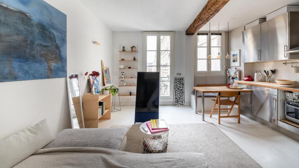 un salon avec un canapé et une cuisine dans l'établissement Stylish 1BD Duplex - Stunning Views near Louvre, à Paris