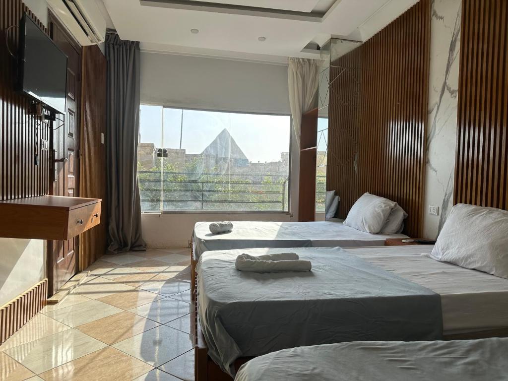 Postel nebo postele na pokoji v ubytování Pyramids Family Inn