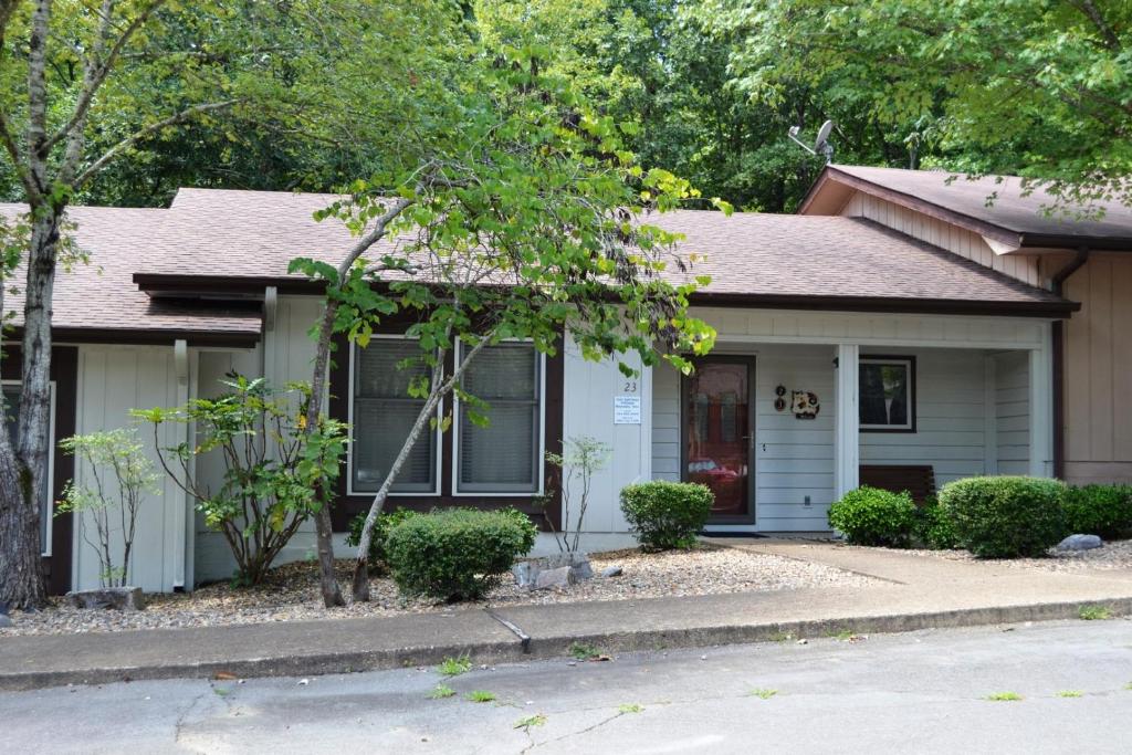 una piccola casa bianca con una porta rossa di 23 Tomisa Lane a Hot Springs Village