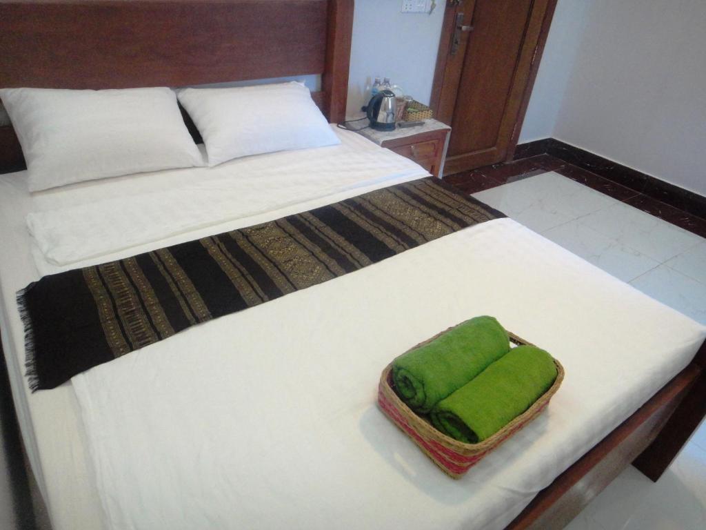 a bed with a green towel on top of it at Marany Guesthouse in Kampot