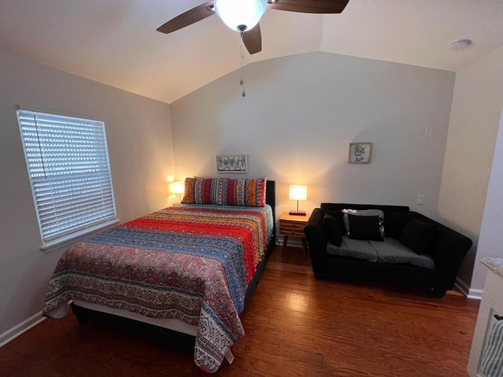 een slaapkamer met een bed, een bank en een plafondventilator bij Lux Studio W Kitchenette Pet Yes in Beaufort