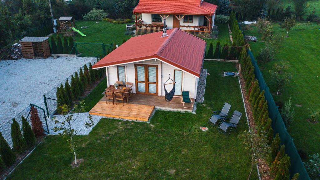 a small house with a red roof on a yard at domek Sybilla in Pieszyce