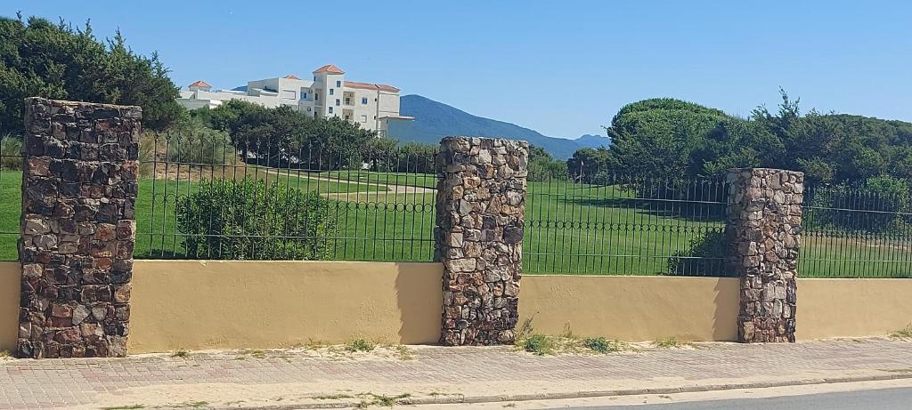 una valla con pilares de piedra frente a un campo en Ahlem, en Tabarka