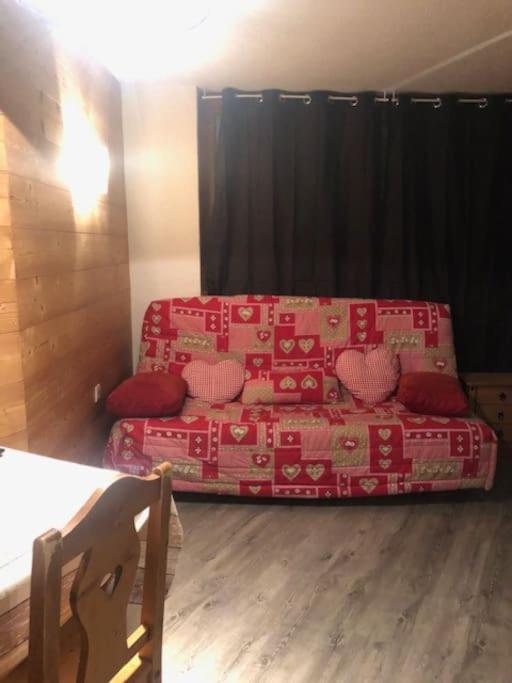 - un salon avec un canapé et une couverture rouge dans l'établissement L'appartement Emma d'Avoriaz, à Avoriaz