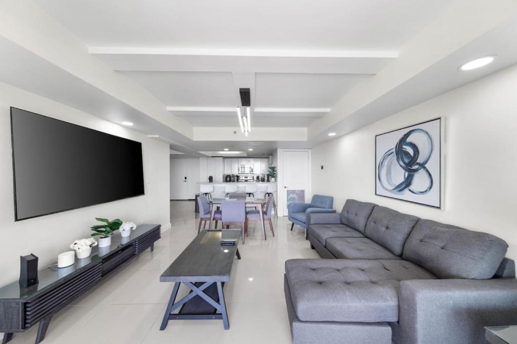 a living room with a couch and a flat screen tv at Stunning Sunsets and SpaceX Views in South Padre Island