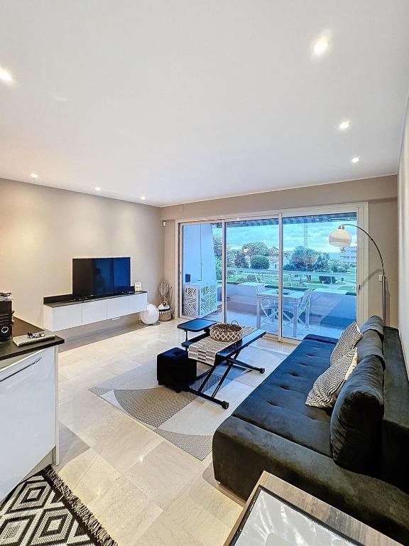 - un salon avec un grand canapé et une télévision dans l'établissement 2Pièces Marina Baie des Anges, à Villeneuve-Loubet