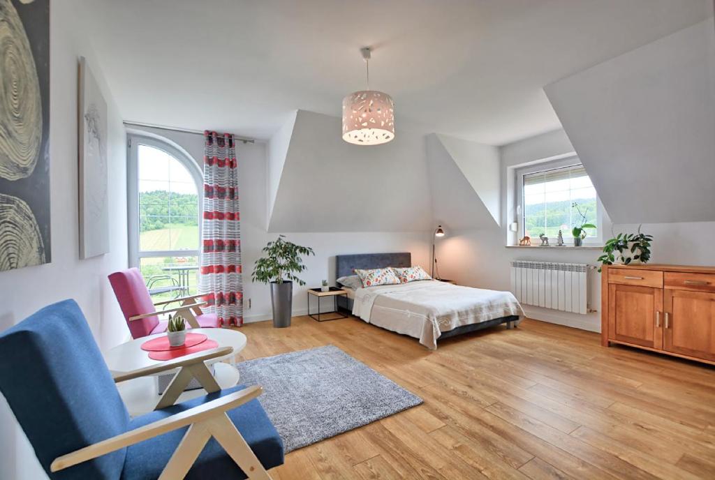 a bedroom with a bed and a table and a chair at Pokoje i apartamenty Ferencówka Bieszczady in Zawóz