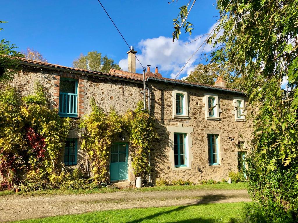 une ancienne maison en pierre avec une porte verte dans l'établissement Gîte le Saint Couette 4 étoiles, charme & confort chic, à Saint-Colombin