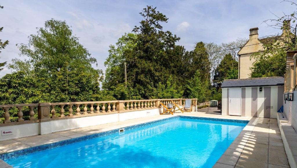 a swimming pool in the backyard of a house at New School Rooms estate close to Bath including heated swimming pool,hot tub,WIFI, pool table, parking in Box