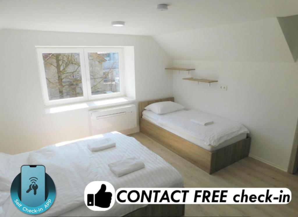 a bedroom with two beds and a window at Evi Rooms Ljubljana in Ljubljana