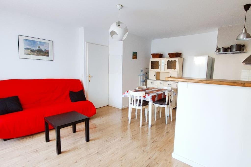 un salon avec un canapé rouge et une table dans l'établissement Agréable T2 avec terrasse Proche gare, à Brétigny-sur-Orge