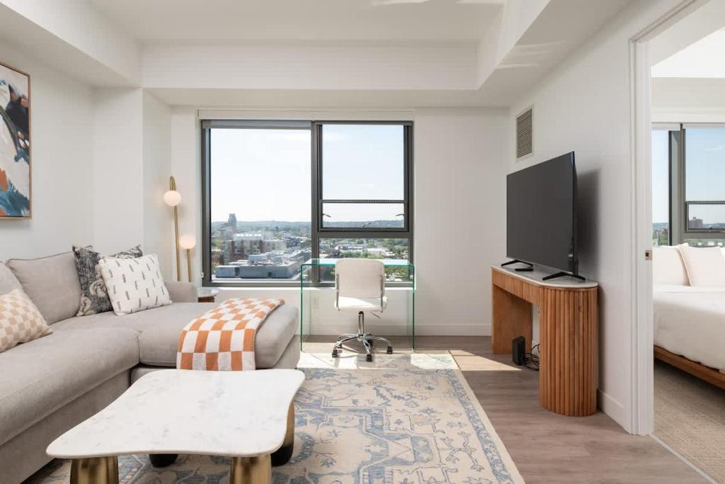 a living room with a couch and a tv at Upscale 1BR near MIT Harvard with Parking in Cambridge