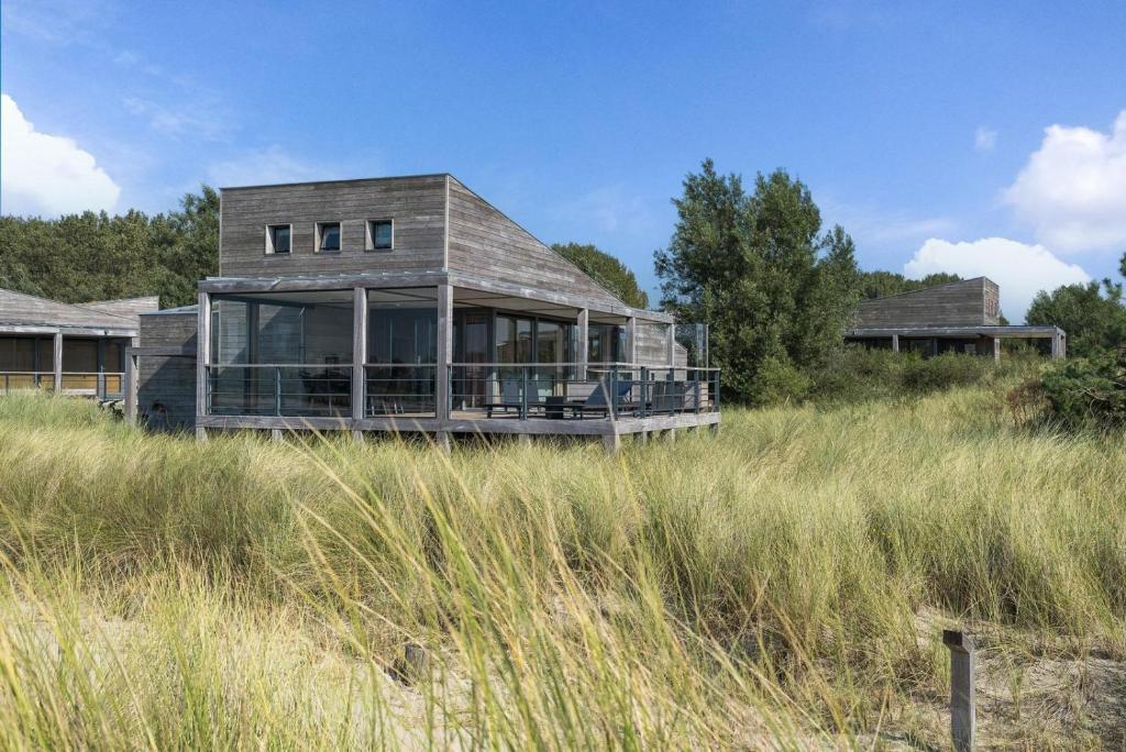 a house sitting in the middle of a field at Luxe Villa met Uitzicht 4p - Luxe, Rust & Water - Villa 67 in Ouddorp