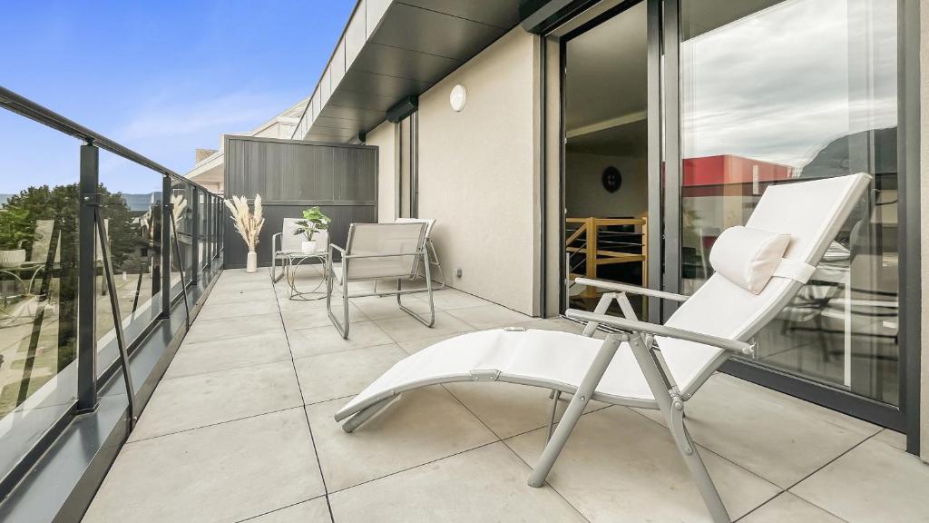 une chaise blanche sur le balcon d'une maison dans l'établissement Homey Luxury - Proche du centre-ville, des transports, de Genève, à Annemasse