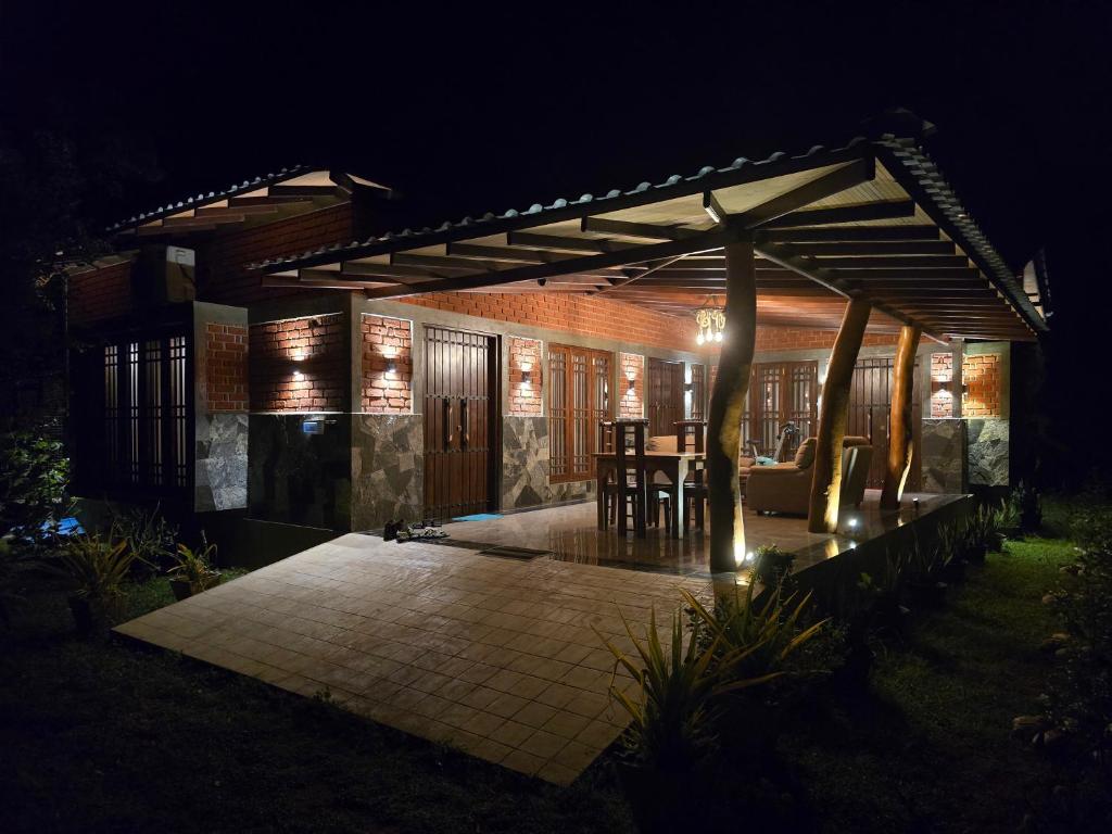 a pavilion with a table and chairs on a patio at night at Ceylon Resort Wilpattu in Wilpattu