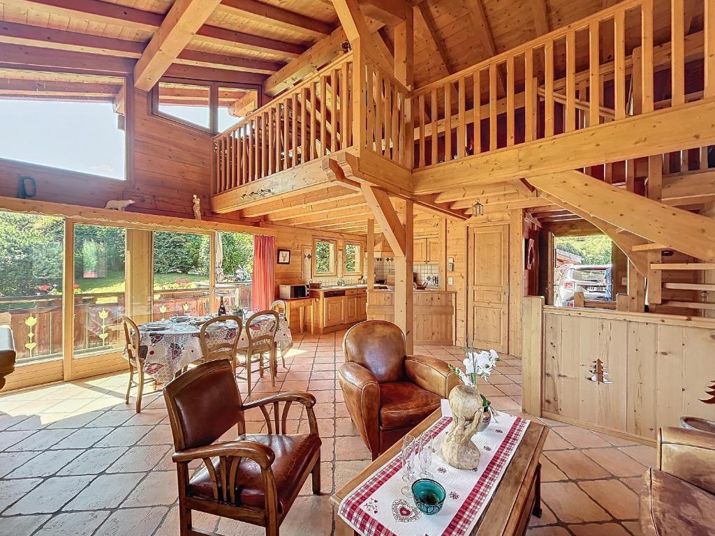 ein großes Wohnzimmer mit einem Tisch und Stühlen in der Unterkunft Chalet individuel avec garage, terrasse, buanderie et cuisine équipée - FR-1-560-149 in Sallanches