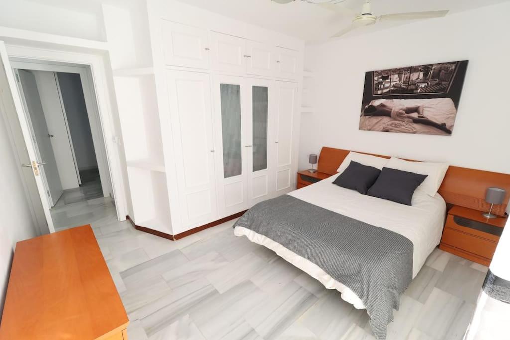 ein weißes Schlafzimmer mit einem Bett und einem Tisch in der Unterkunft Rincón de Sierra Nevada in Cenes de la Vega