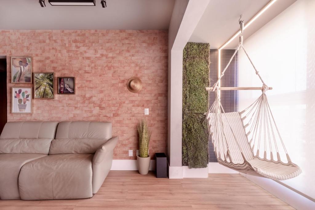a living room with a couch and a hammock at PALMAS EXPERIENCE - APARTAMENTO CONTEMPORÂNEO, vista serra, na quadra do shopping in Palmas
