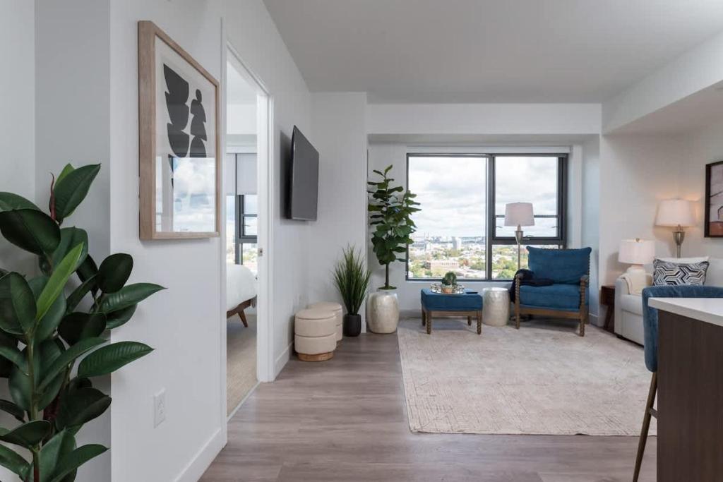a living room with white walls and a living room with blue chairs at Upscale Penthouse near MIT Harvard Central Square in Cambridge