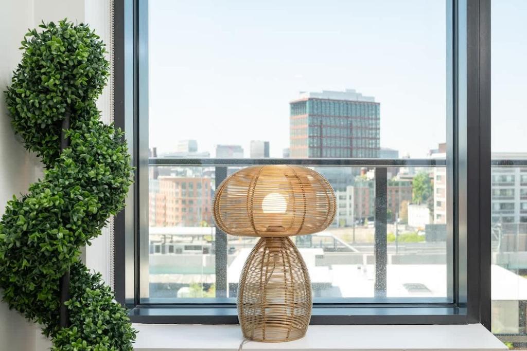 a wicker lamp sitting on a window sill at Luxury Apartment w King Bed Shared Pool & Rooftop in Cambridge