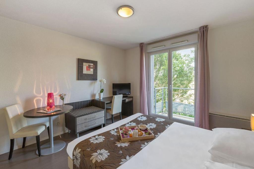 une chambre avec un lit, une table et un bureau dans l'établissement Le refuge urbain de Toulouse - ancien appartcity, à Toulouse