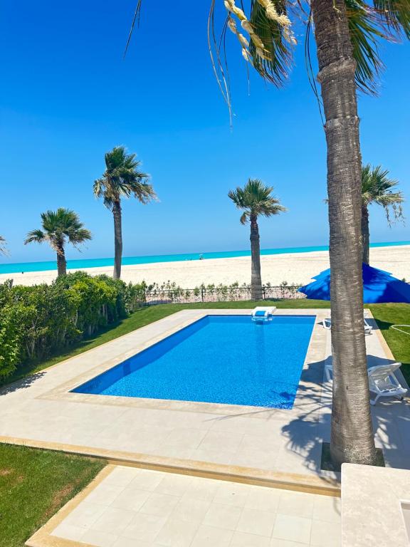 فيلا أول صف على البحر مارينا 5الساحل الشمالي 7 غرف كود 88 في العلمين: مسبح بجانب الشاطئ يوجد به نخيل