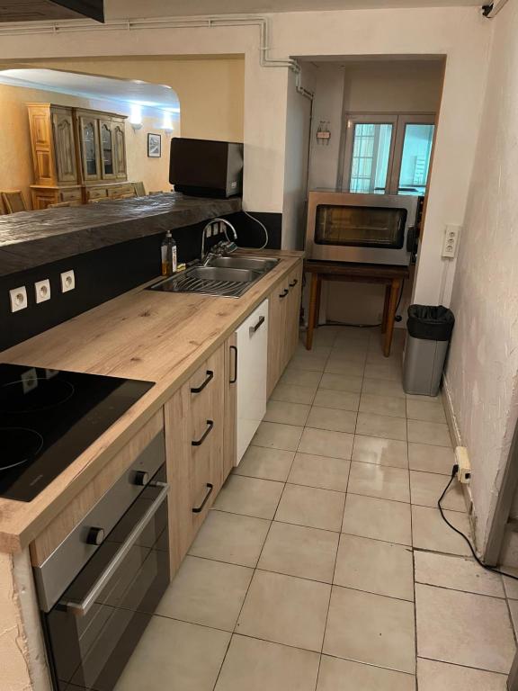 a kitchen with a sink and a stove top oven at Belle rivière en Cévennes in Corbés