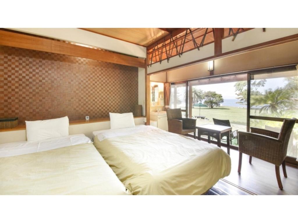 a bedroom with two beds and a table and chairs at Japari Tateyama - Vacation STAY 76023v in Tateyama